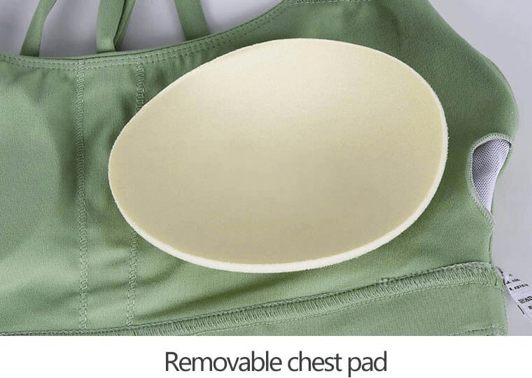 Green sports bra with removable yellow chest pad on top, highlighting versatile and comfortable design for active wear.