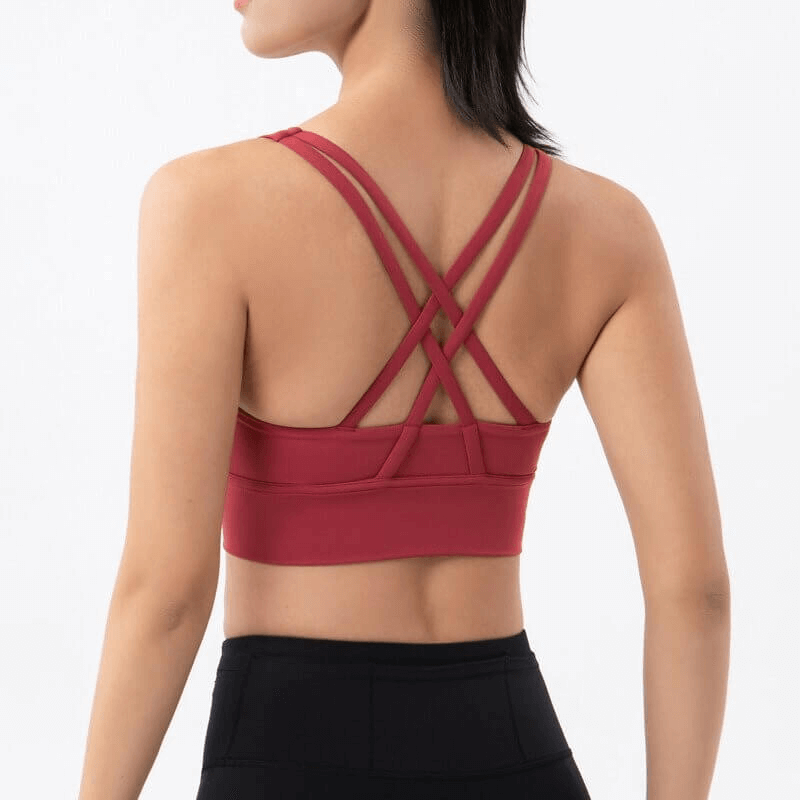 Back view of woman wearing red nylon sports top with cross shoulder straps, ideal for yoga, gym, and dance sessions, SF0036.
