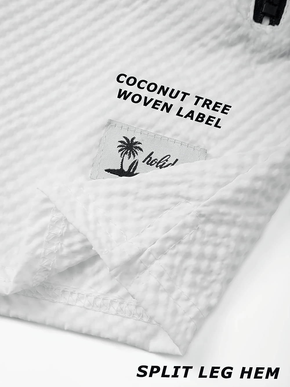 Alt Tag: Ombre Drawstring Swim Shorts with Zipper Pockets - SF4534 close-up of white textured fabric, coconut tree woven label, split leg hem