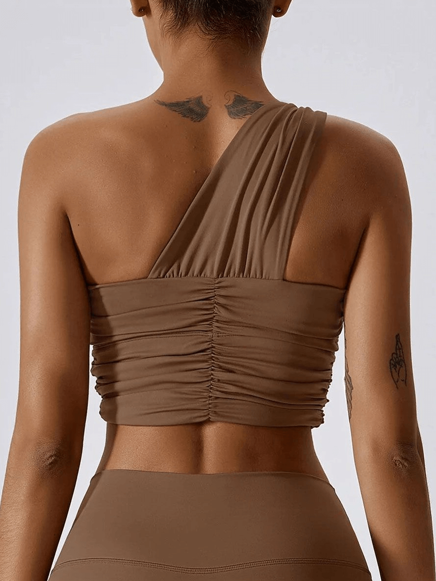 One Shoulder Backless Yoga Sports Bra in brown shown from the back, featuring adjustable straps for comfortable support. Model wearing bra.