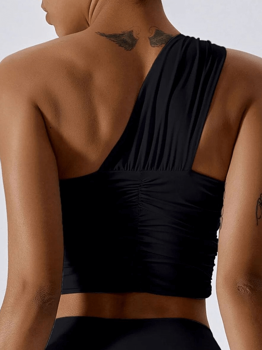Woman wearing one shoulder backless yoga sports bra, black, breathable nylon spandex, ideal for fitness activities like yoga, SF1769.