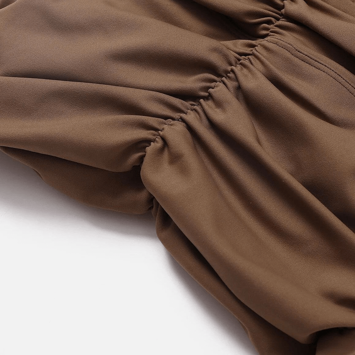 Close-up of brown gathered fabric with a soft, flowing texture.