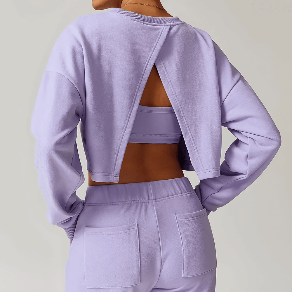 Model wearing lavender open-back long sleeve sweatshirt with pockets, showcasing breathable fabric and loose fit, perfect for active women.