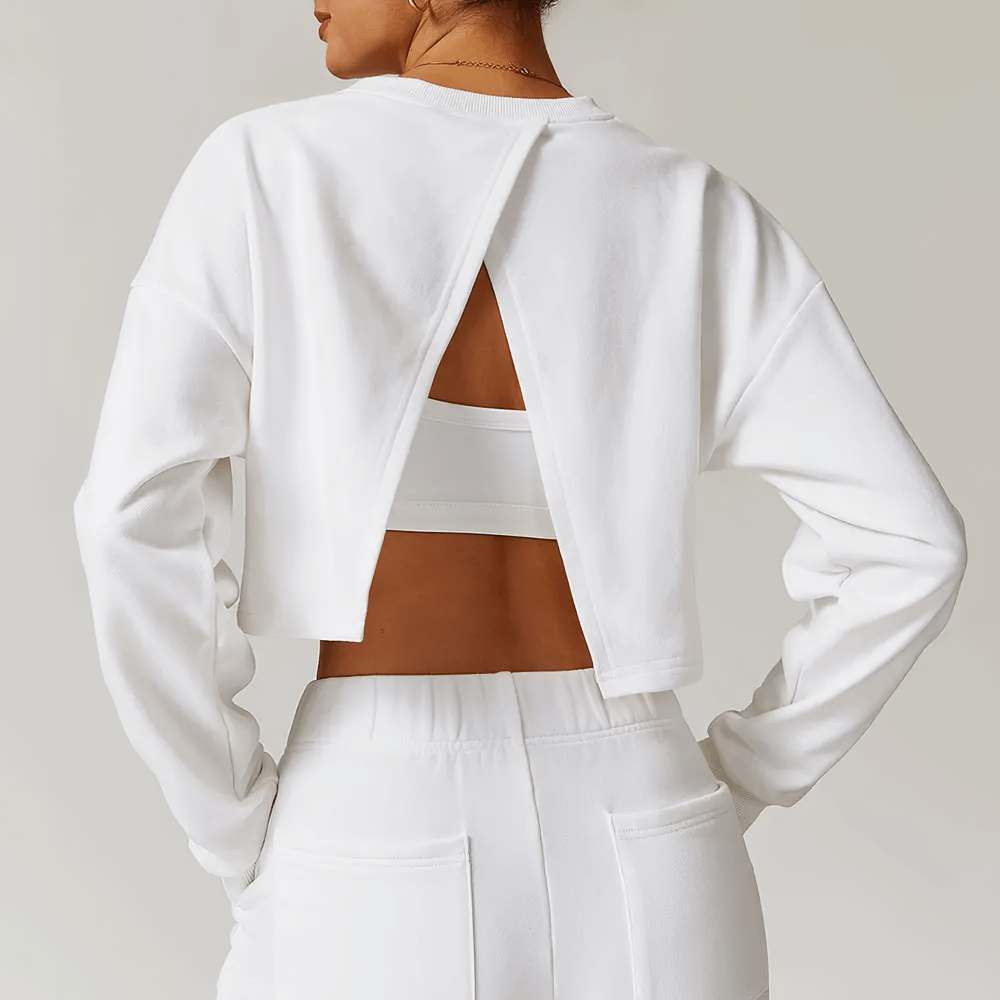 Back view of woman wearing open back long sleeve white sweatshirt, highlighting stylish design and breathable fabric for activewear