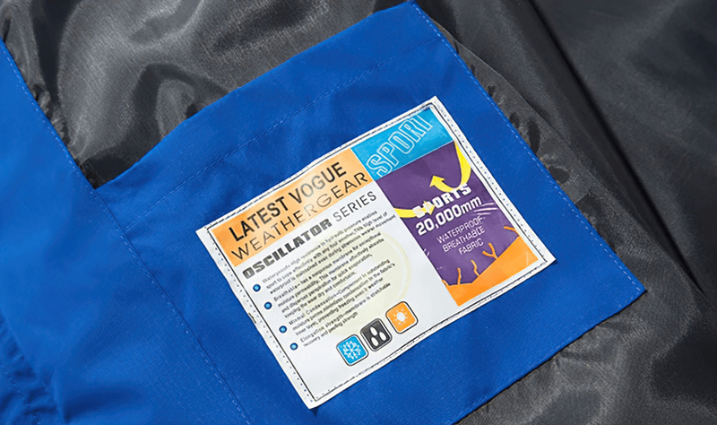 Close-up of label inside blue waterproof windbreaker jacket, detailing weather resistance and material information.