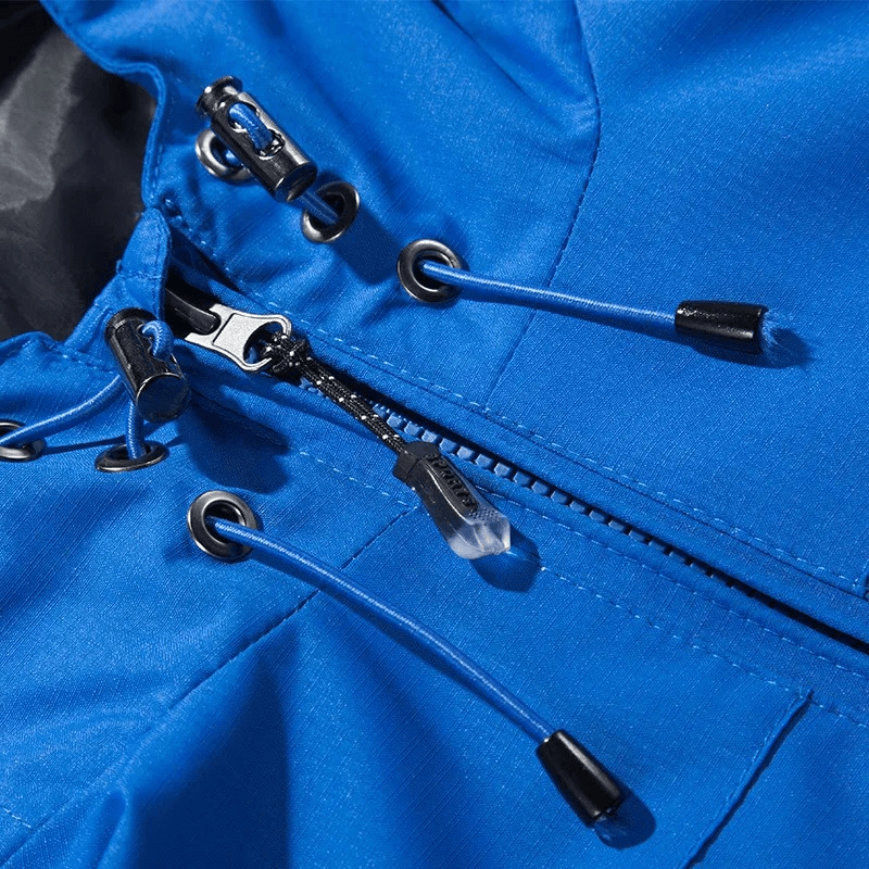 Close-up of blue hooded waterproof windbreaker jacket with zipper closure and drawcords, perfect for outdoor adventures.