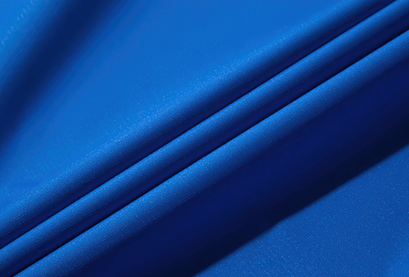 Close-up of vibrant blue waterproof fabric showcasing the texture and quality for outdoor jackets.