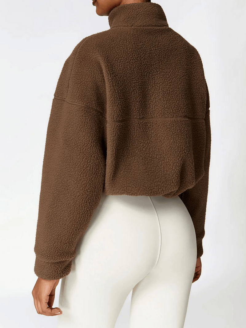 Woman wearing brown fleece jacket with full sleeves and zipper, perfect for outdoor sports and yoga.