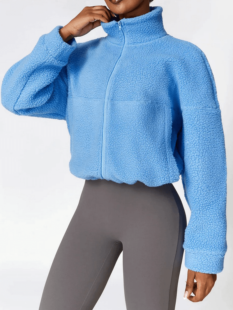 Woman wearing blue outdoor fleece jacket with long sleeves and zipper, perfect for sports and yoga. Anti-pilling and anti-shrink fabric.