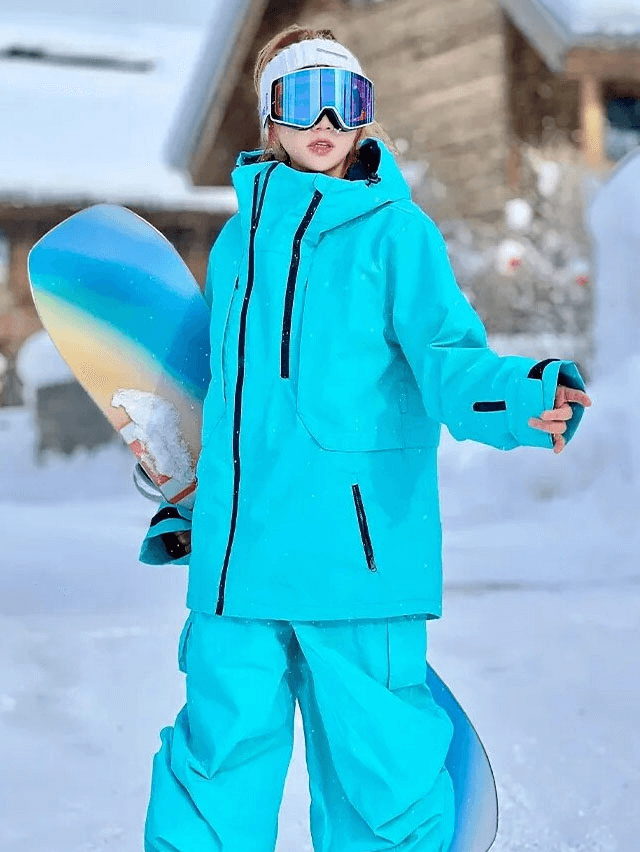 Person wearing blue unisex ski jacket holding snowboard, showcasing waterproof and windproof design, ideal for cold weather skiing.