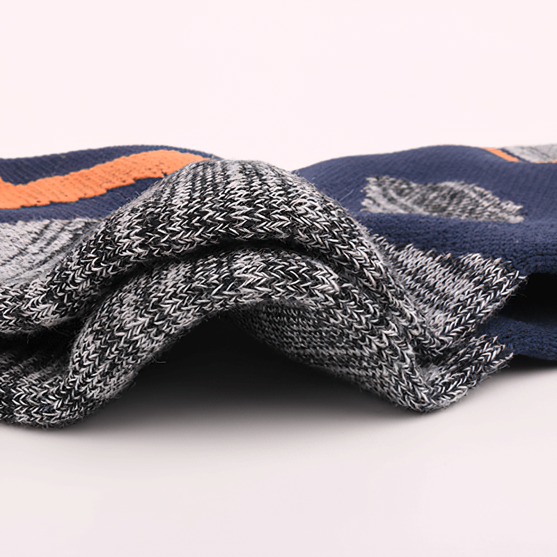 Close-up of soft, thickened hiking socks in gray and navy with an orange stripe, showcasing breathable, anti-friction fabric.