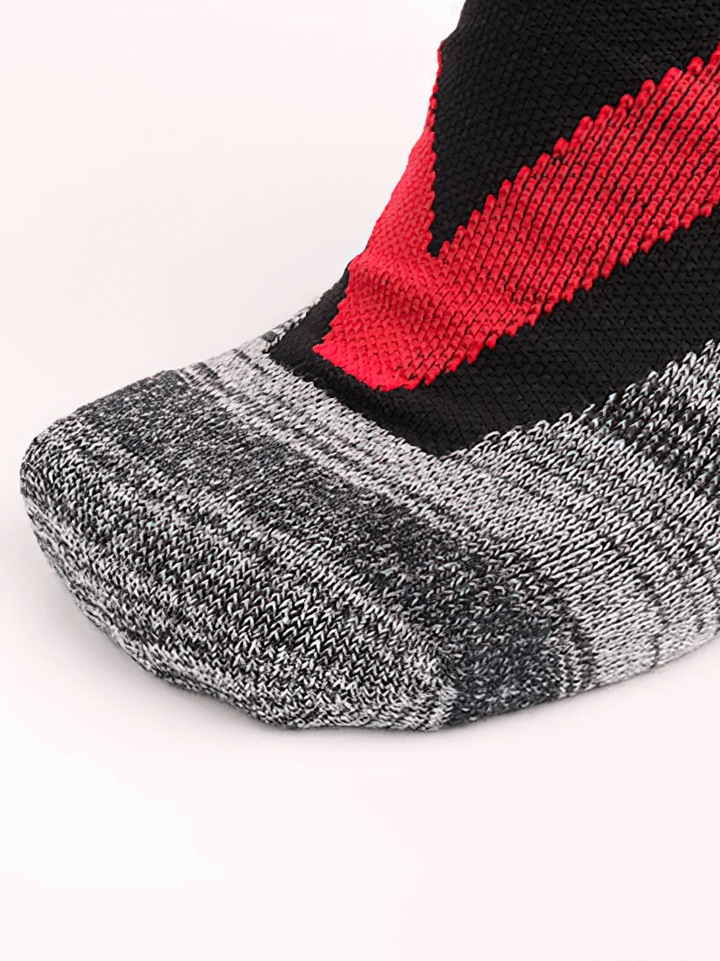 Close-up of thick gray, red, and black skiing socks with anti-friction fabric, perfect for outdoor sports and hiking.