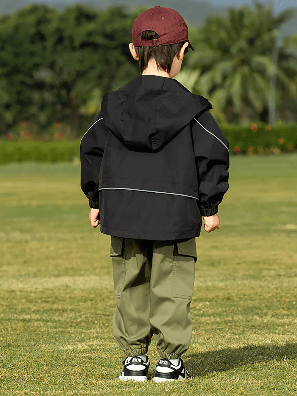 Child wearing Outdoor Waterproof Children's Windbreaker Jacket - SF3571 enjoying a fun day outside with trees in the background.