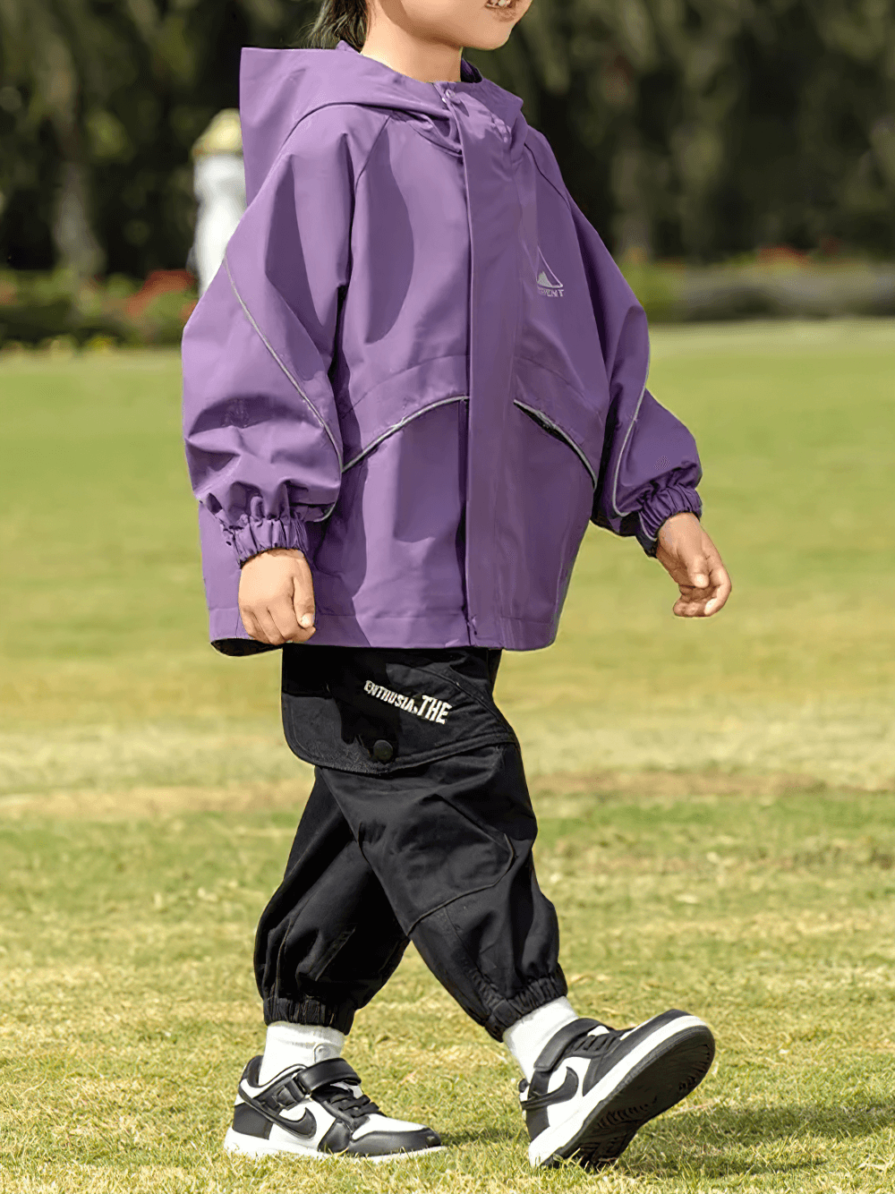 Child wearing Outdoor Waterproof Children's Windbreaker Jacket - SF3571 in purple, enjoying a sunny day outdoors.