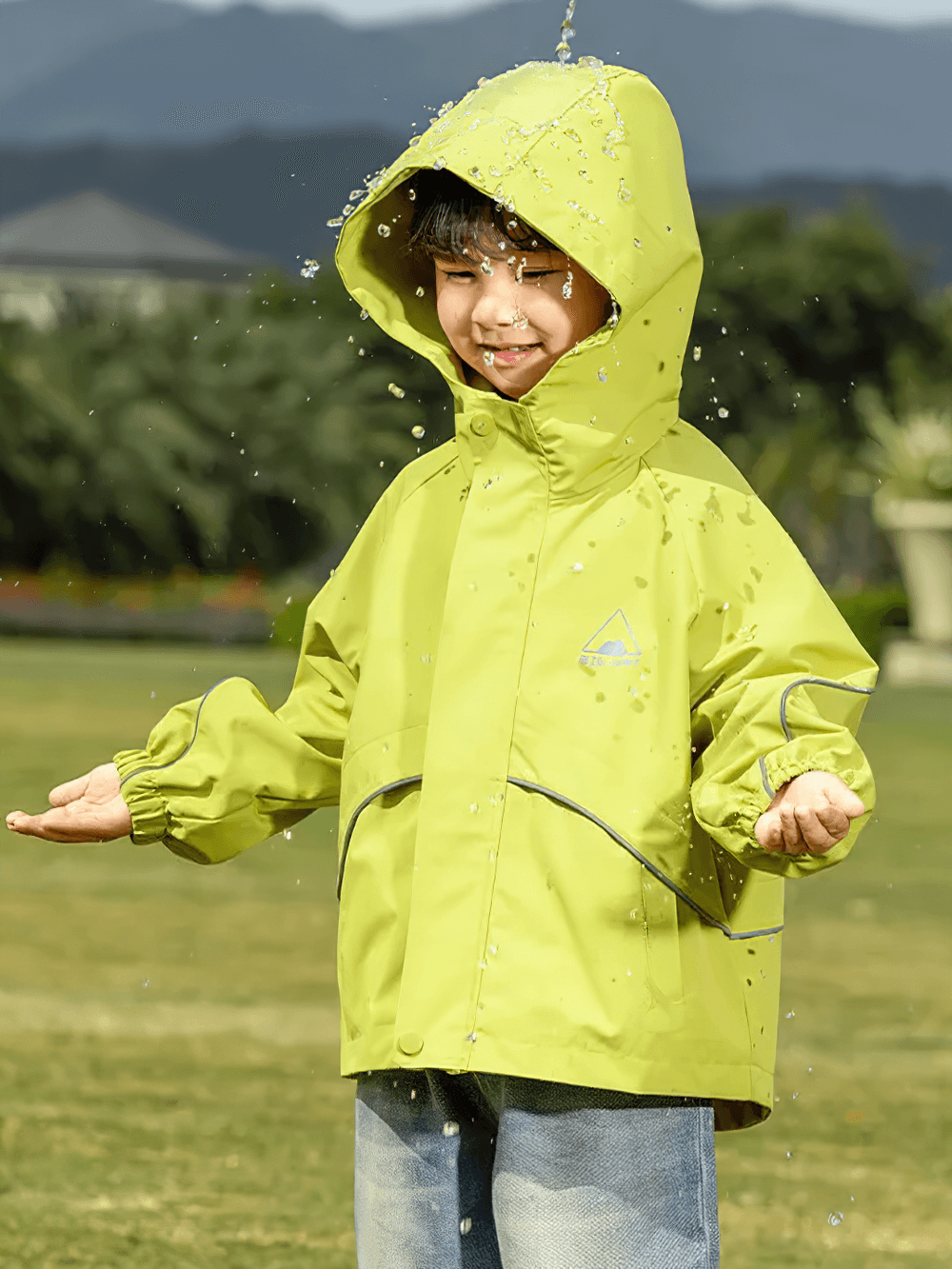 Child playing in the rain wearing Outdoor Waterproof Children's Windbreaker Jacket - SF3571 in a vibrant design.