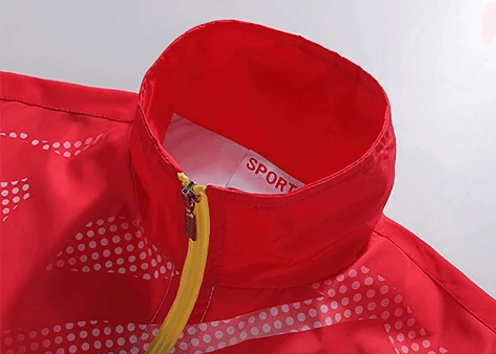 Red gradient waterproof sports jacket detail with yellow zip and breathable fabric, perfect for outdoor activewear hiking and running.