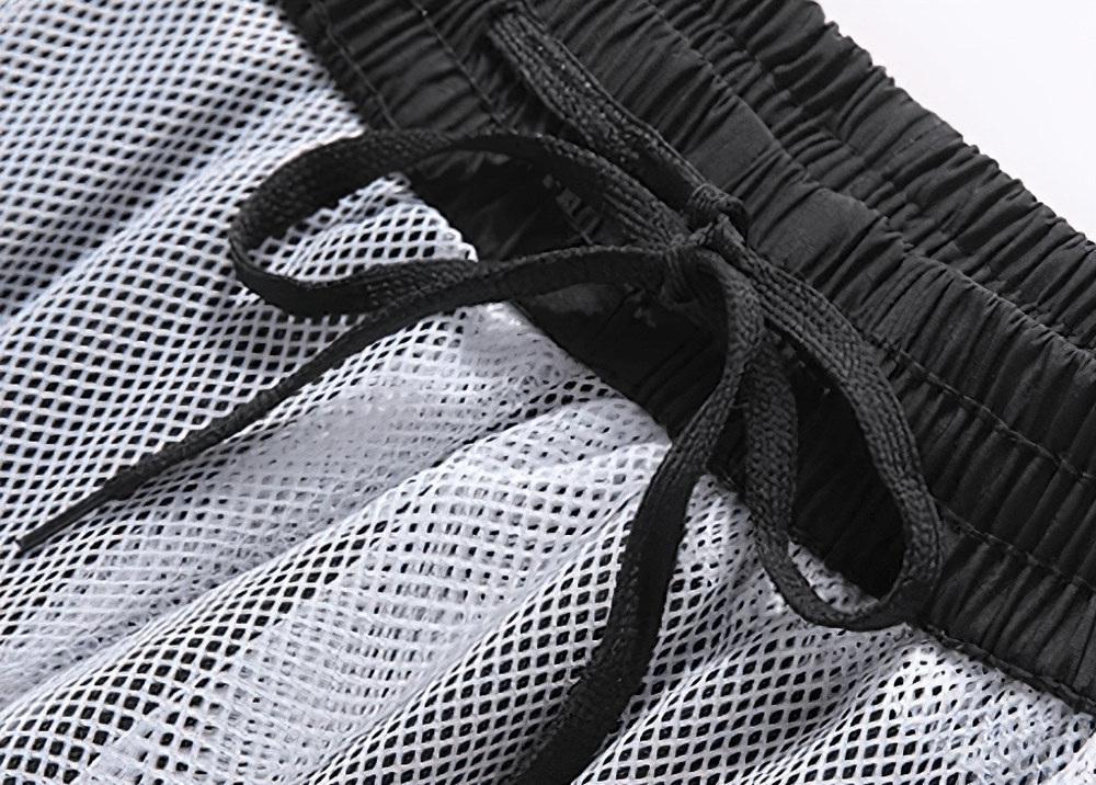 Close-up of black elastic waist with drawstring on breathable mesh sportswear, showcasing durability and comfort.