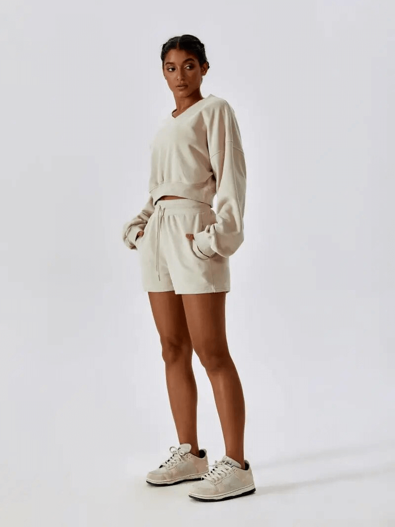 Woman wearing fitness cotton loose sweatshirt and shorts set for yoga, showcasing comfort and flexibility.