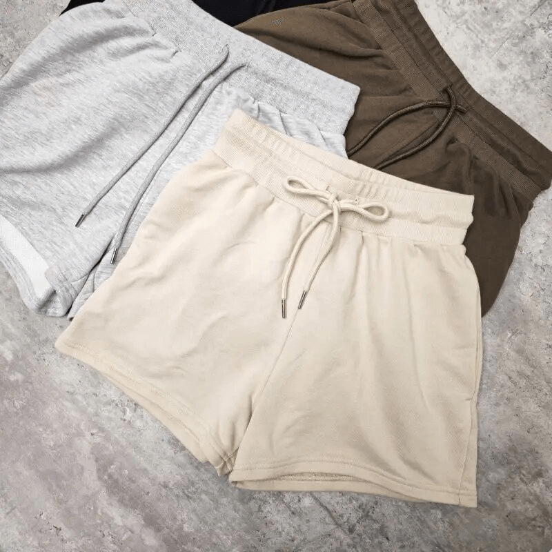 Three pairs of cotton shorts in grey, beige, and brown, perfect for yoga and fitness activities.