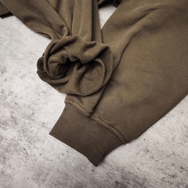 Close-up of brown cotton sweatshirt sleeve showing ribbed cuff and soft texture for comfort and style in fitness apparel.
