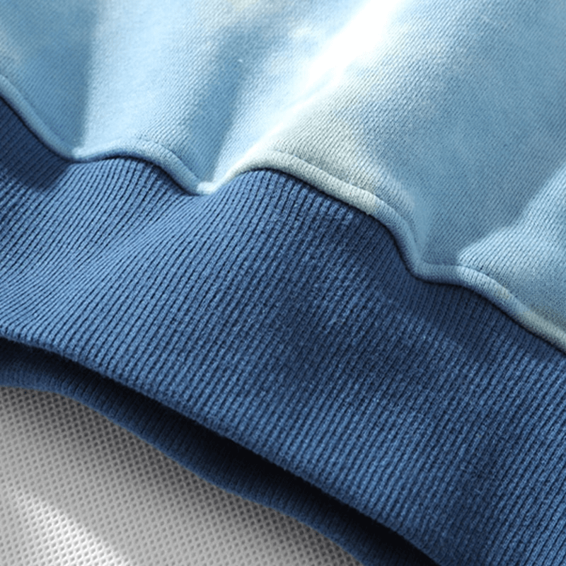 Close-up of blue oversized cotton hoodie showcasing ribbed hem for a trendy, loose fit. Perfect men's casual wear.