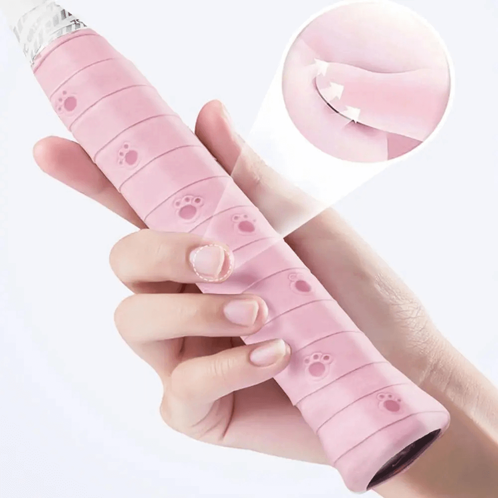 Close-up of a hand holding a pink Paw Print Sports Overgrip Tape for Racket Handles - SF3460, showing paw prints and adhesive detail.