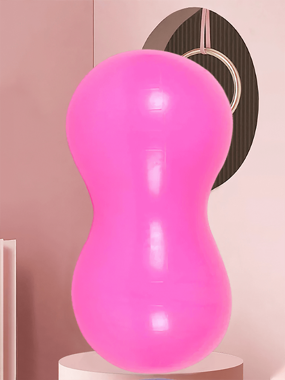 Bright pink peanut-shaped exercise ball for yoga and core training, anti-burst, non-slip surface, ideal for Pilates and rehabilitation.
