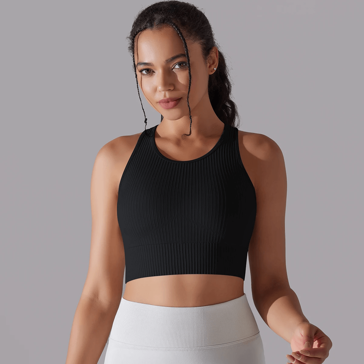 Woman wearing black ribbed yoga short tank top, perfect for activewear and yoga sessions with snug fit and full movement.