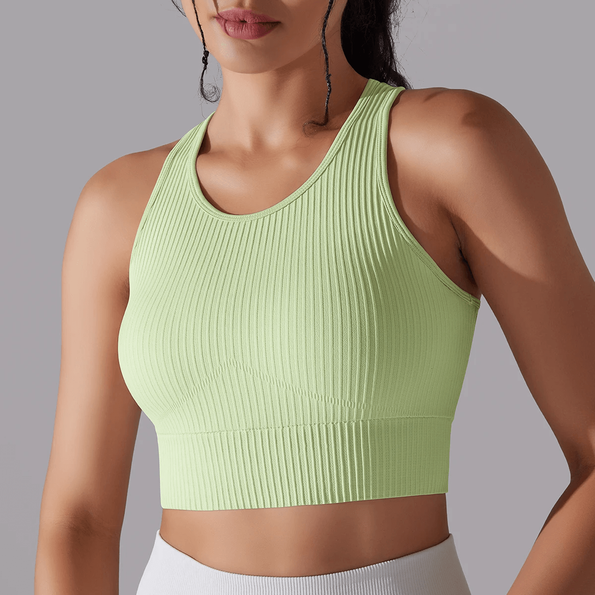 Woman wearing light green ribbed yoga short tank top for women, perfect for active wear and yoga sessions.