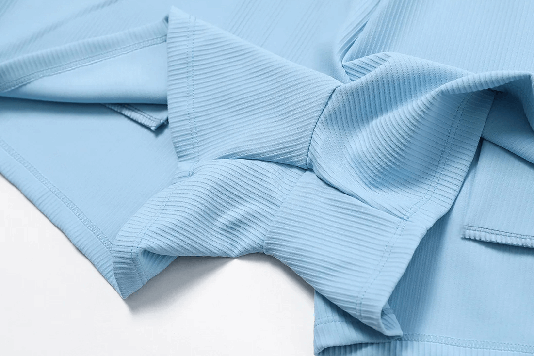 Close-up of ribbed light blue workout fabric, showcasing texture and design details ideal for gymwear.