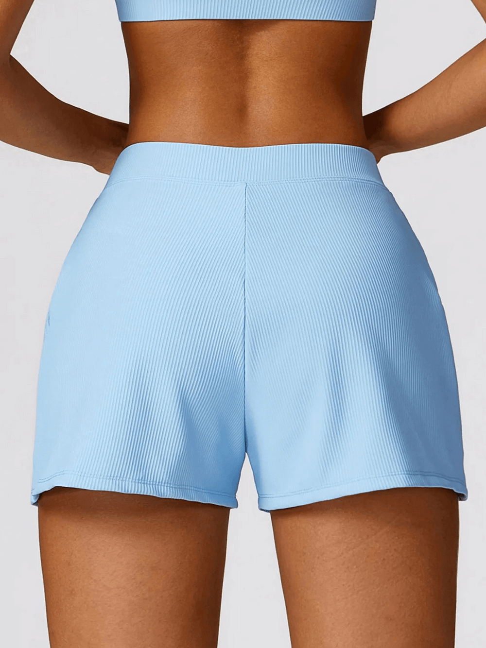 Back view of blue high waist workout shorts for women with ribbed waistband, designed for yoga and gym. Moisture-wicking fabric.