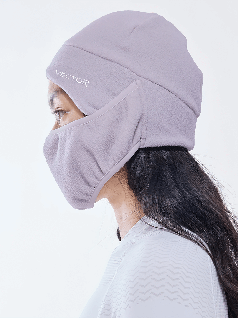 Profile view of a woman wearing a windproof polar fleece balaclava hat with face protection, showcasing its snug fit and sleek logo.