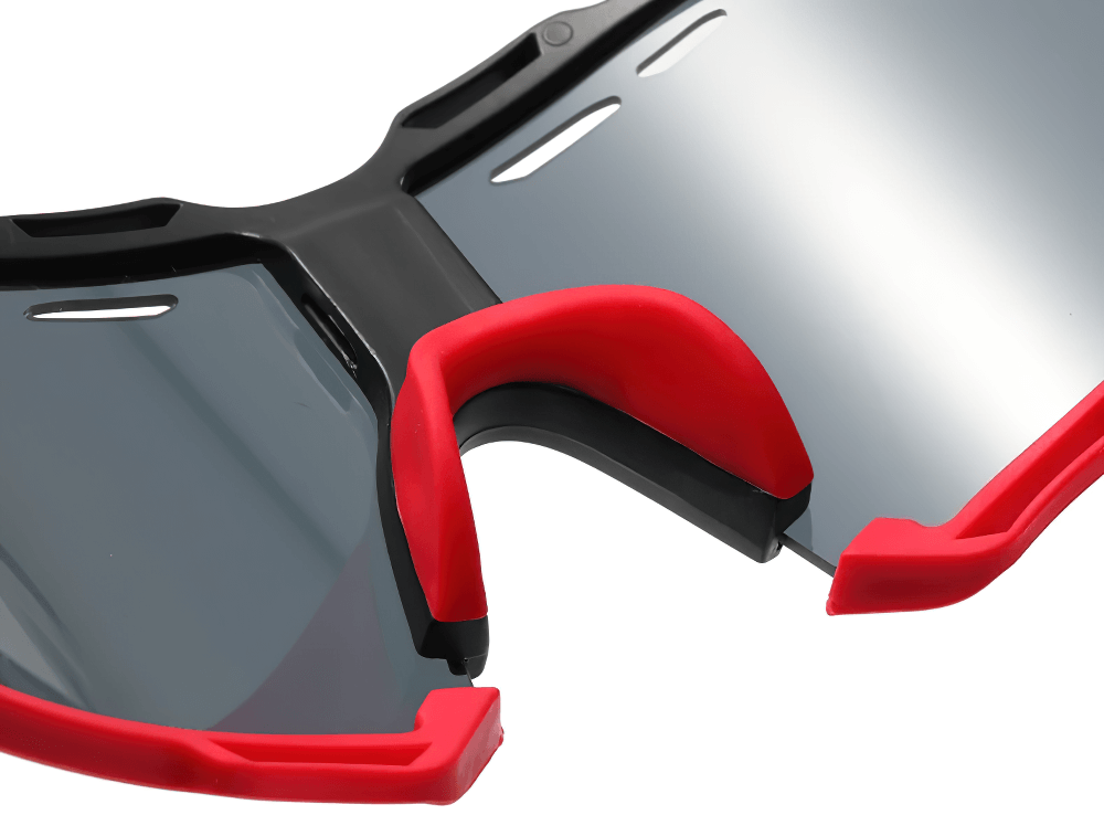 Close-up of multi-color polycarbonate half-rim cycling sunglasses with red accents and clear lens for road biking.