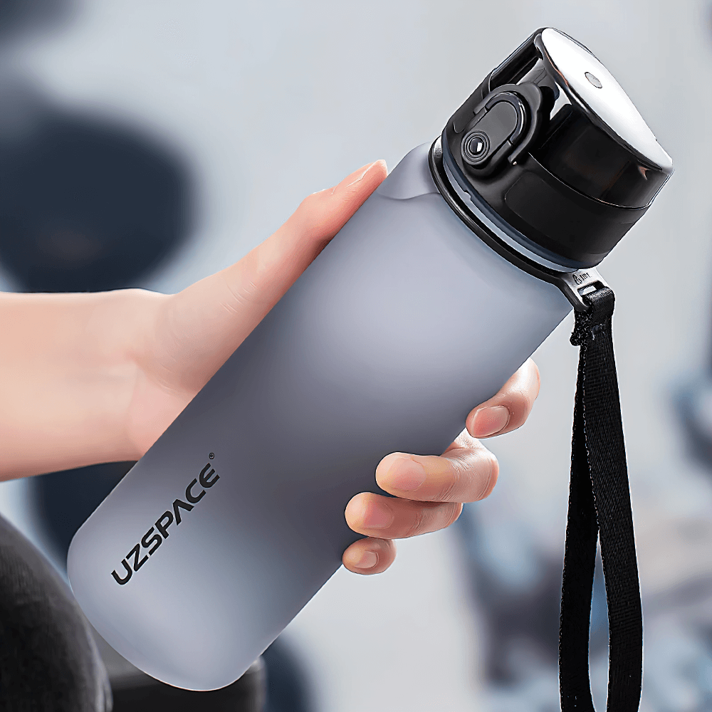Hand holding a portable leak-proof sports water bottle with strap, model SF3068, made of durable Tritan material, ideal for outdoor use.