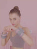 Woman wearing pastel adjustable wrist weights for fitness workout in a gym setting.