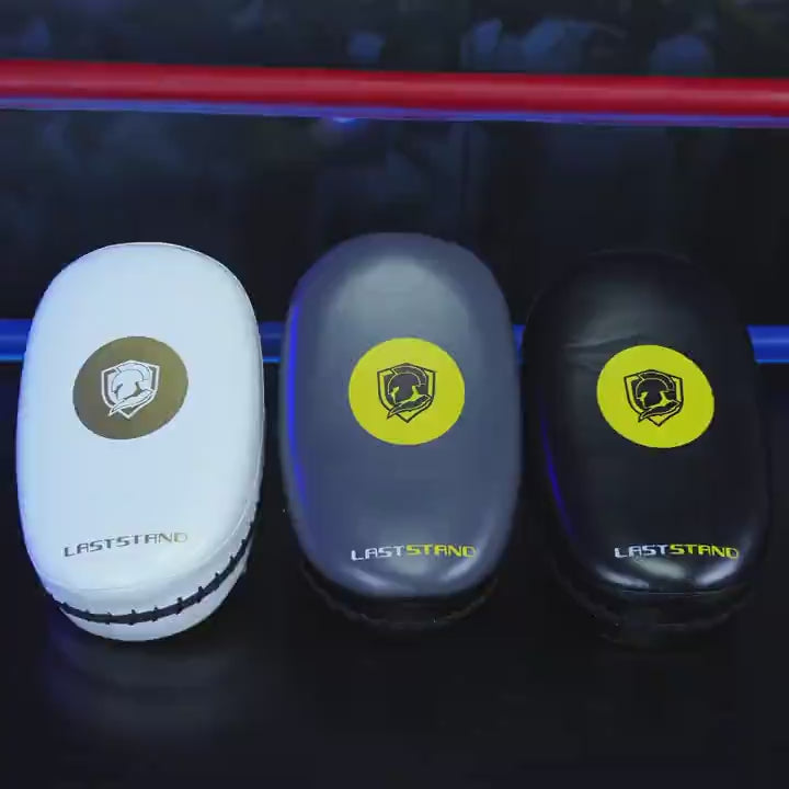 Three Muay Thai kick pads with dual arm straps for martial arts training, featuring a sleek design with durable reinforced stitching.