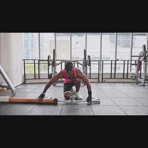 Person in a gym setting preparing a curl barbell with spring collars for a workout session.