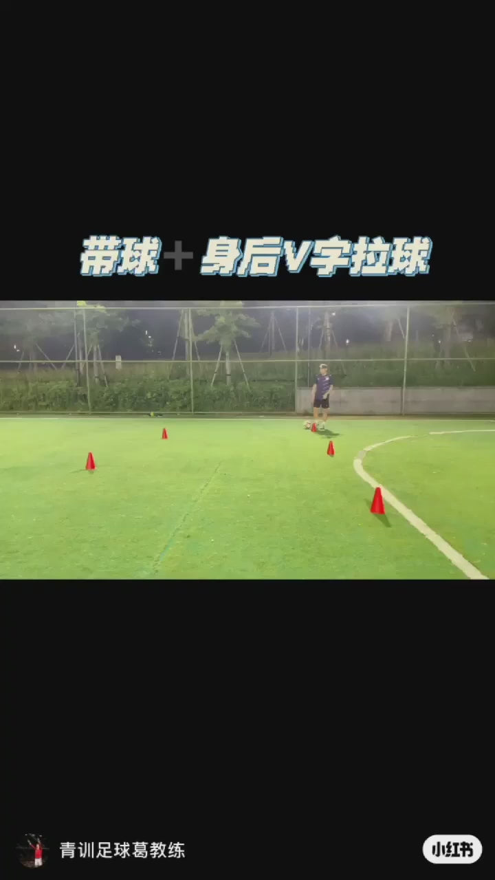 Person practicing soccer agility drills with red training cones on a field during nighttime.