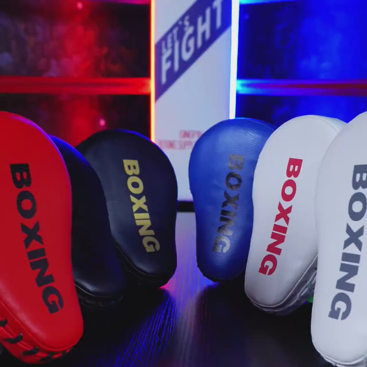 Colorful curved boxing focus pads on display, ideal for MMA and kickboxing training with durable PU leather and five-finger glove grip.