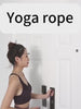 Woman preparing to use aerial yoga rope for home gym stretching and inversion therapy.