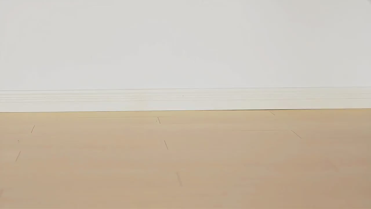 Empty wooden floor with a plain white wall background.