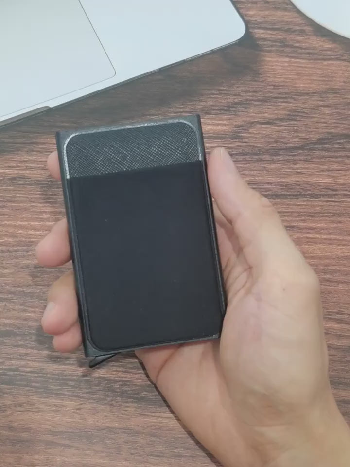 Person holding a slim RFID-blocking aluminum card holder wallet, showcasing its minimalist design and durable construction.