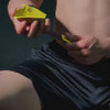 Close-up of a person holding yellow gym equipment, focusing on grip strength enhancement for powerlifting and strength training.