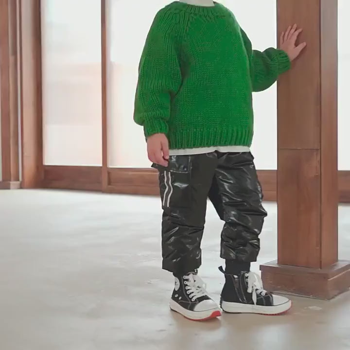 Child wearing Kids Waterproof Cargo Pants with Down Insulation - SF3779, perfect for winter sports, standing indoors in a green sweater.