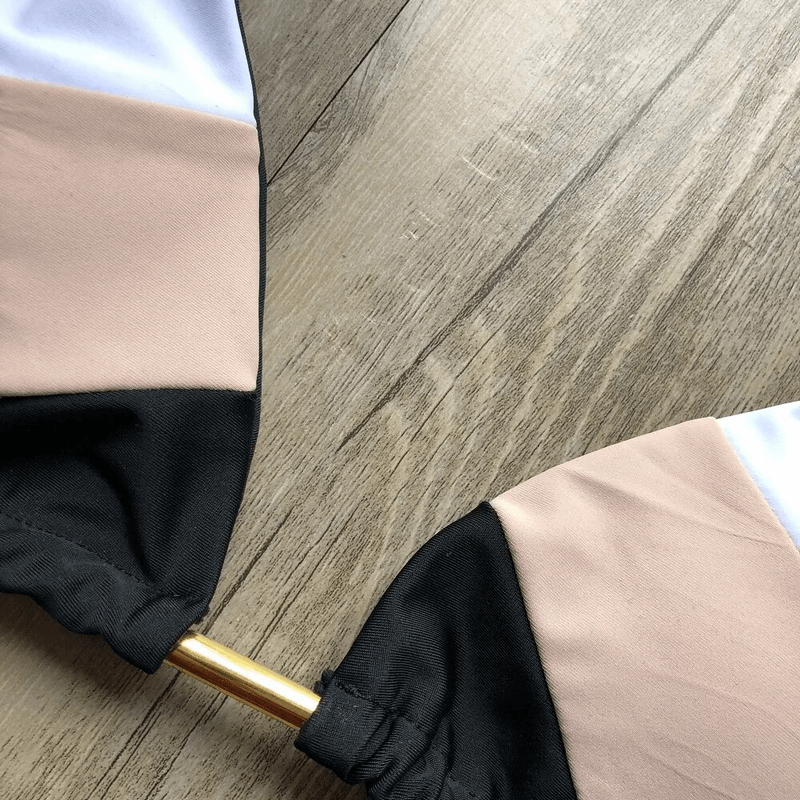 Close-up of printed lace-up swimsuit with patchwork design on wooden background, highlighting nylon material and craftsmanship.