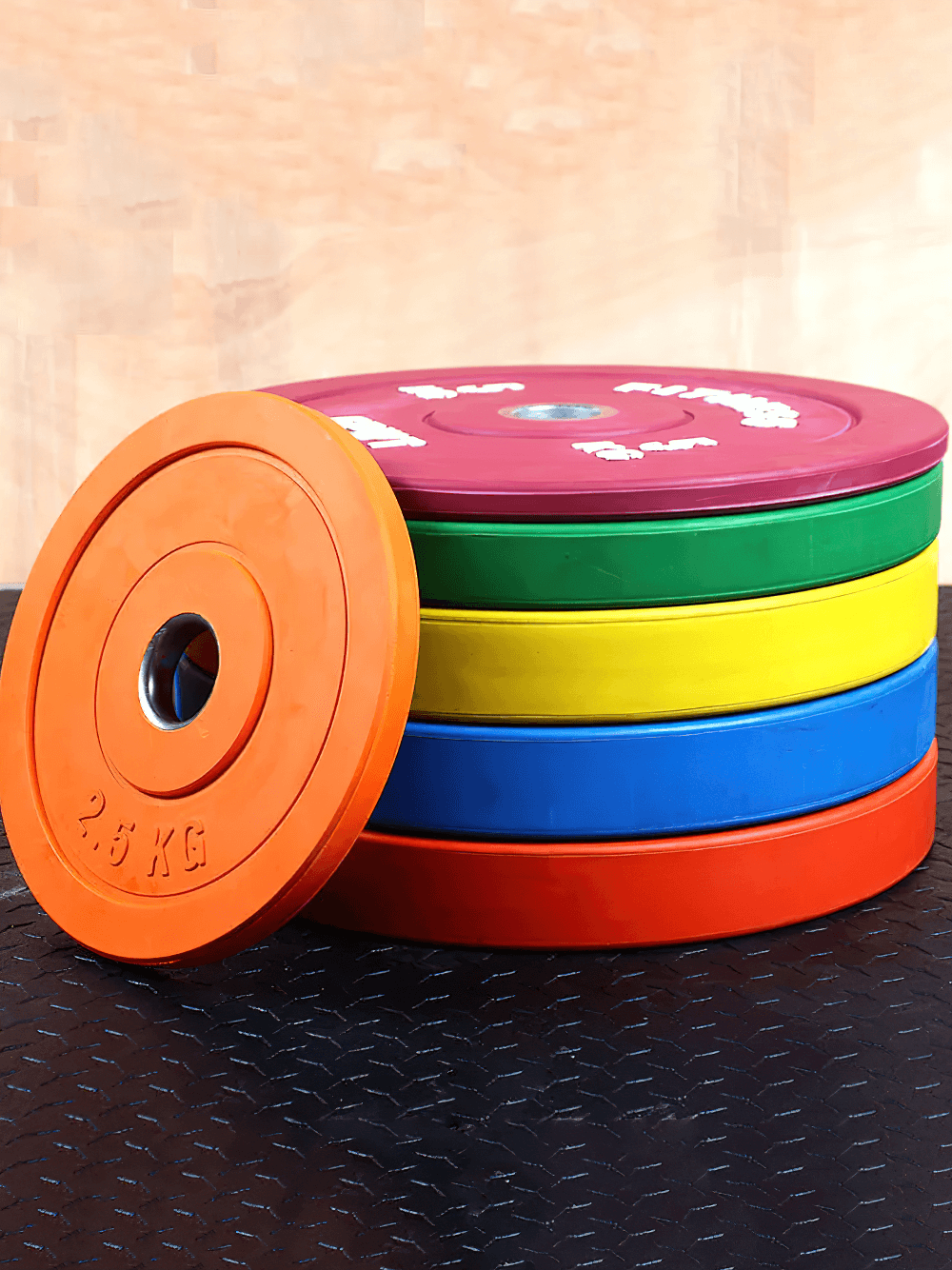 Stack of colorful rubber barbell weight plates for gym use, designed for durability and performance, perfect for all fitness levels.