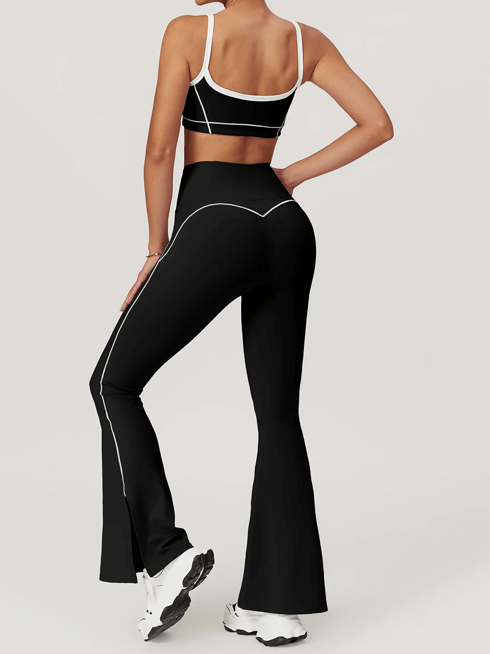 Back view of woman in black push-up sports bra and leggings set, designed for yoga and fitness with breathable spandex support.