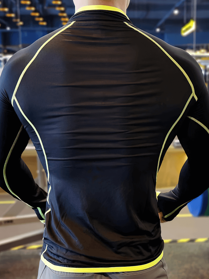 Back view of a men's black quarter-zip long sleeves compression top, designed for bodybuilding with spandex material and bright piping.