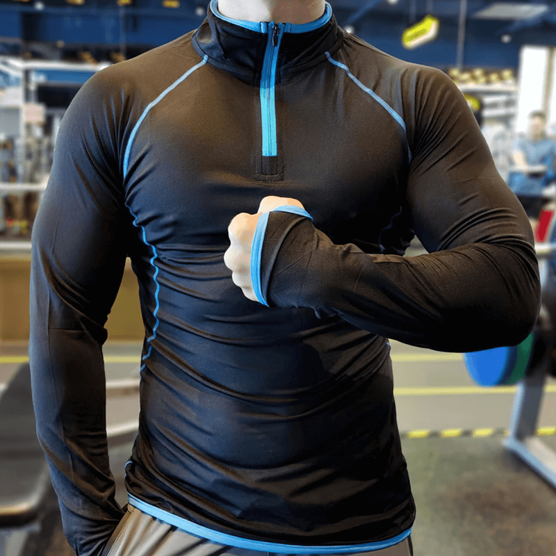 Man wearing SF1950 Quarter-Zip Long Sleeves Compression Top in gym, showcasing form-fitting spandex and sleek design.