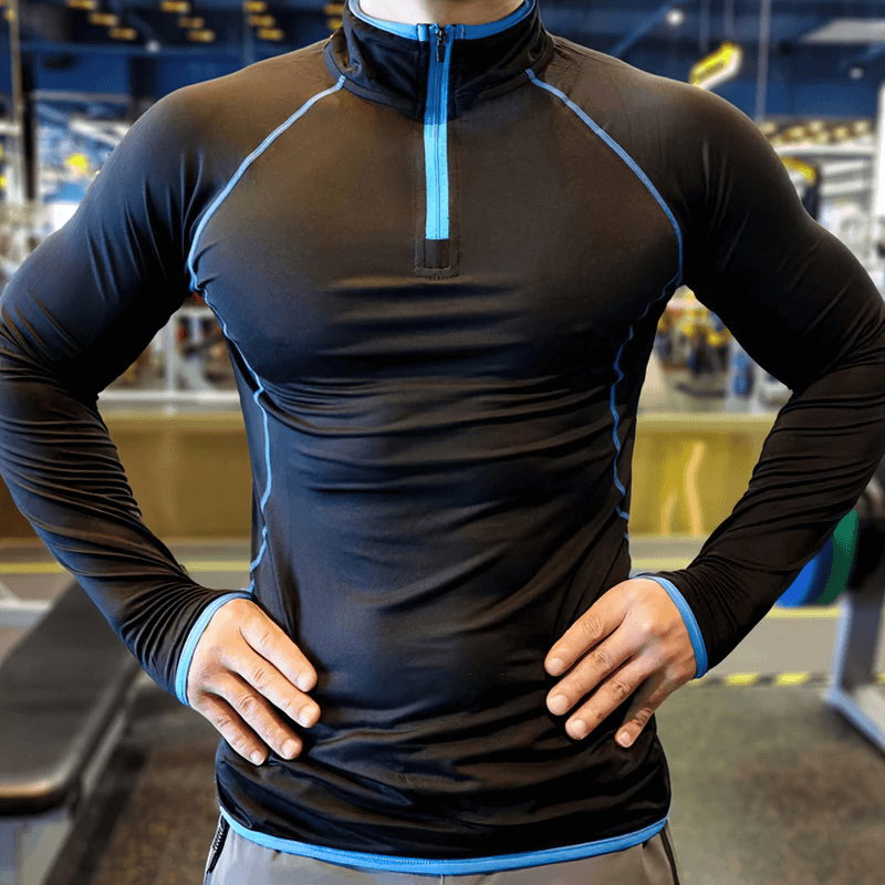 Male model wearing black Quarter-Zip Long Sleeves Compression Bodybuilding Top SF1950, showcasing fit and design in a gym.